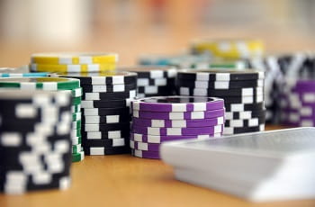 Pokerchips und Spielkarten auf einer Tischfläche.