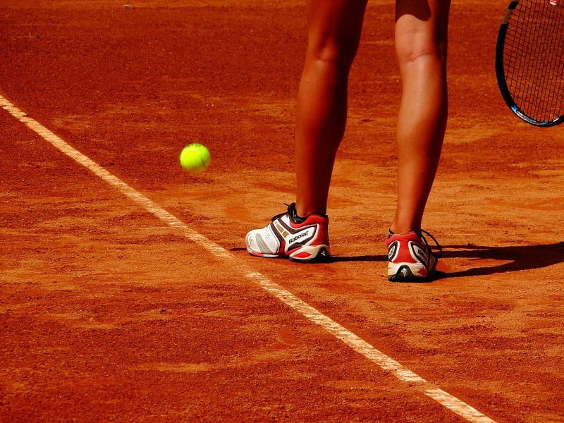 Die Beine einer Tennisspielerin auf dem Feld.