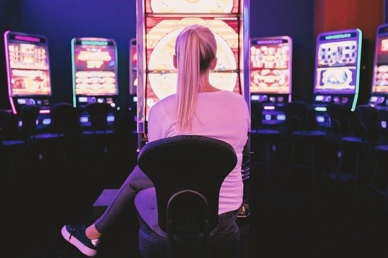 Frau spielt am Spielautomaten in einer Spielhalle.